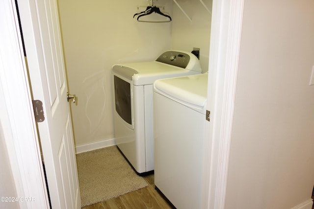 washroom with separate washer and dryer and light hardwood / wood-style flooring