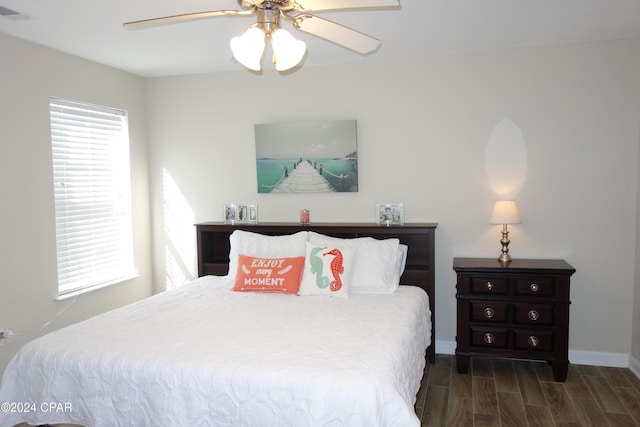 bedroom with dark hardwood / wood-style floors and ceiling fan