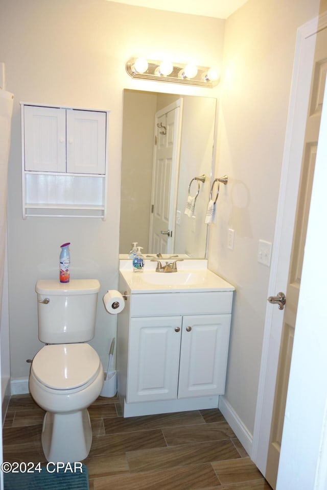 bathroom with vanity, hardwood / wood-style flooring, and toilet