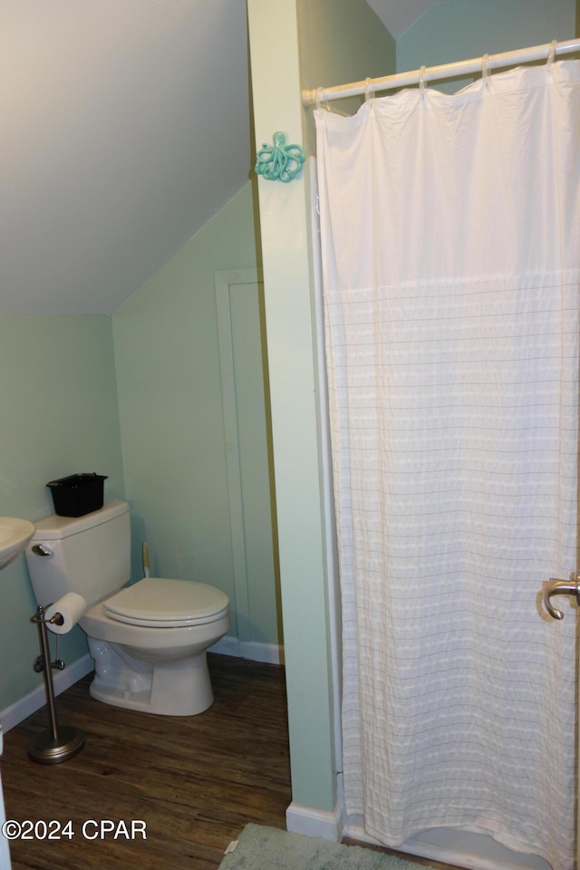 bathroom with hardwood / wood-style flooring, toilet, and vaulted ceiling