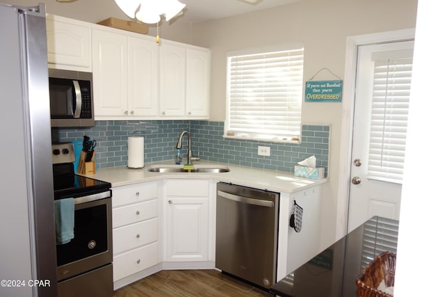 kitchen featuring white cabinetry, sink, dark hardwood / wood-style floors, backsplash, and appliances with stainless steel finishes