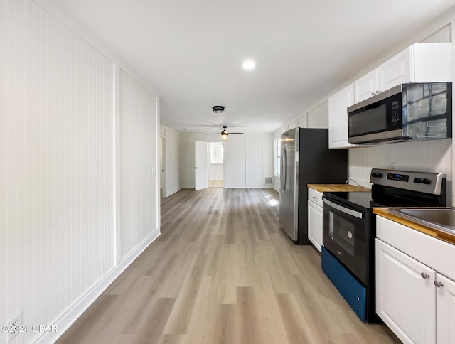 kitchen with white cabinetry, sink, ceiling fan, stainless steel appliances, and light hardwood / wood-style floors