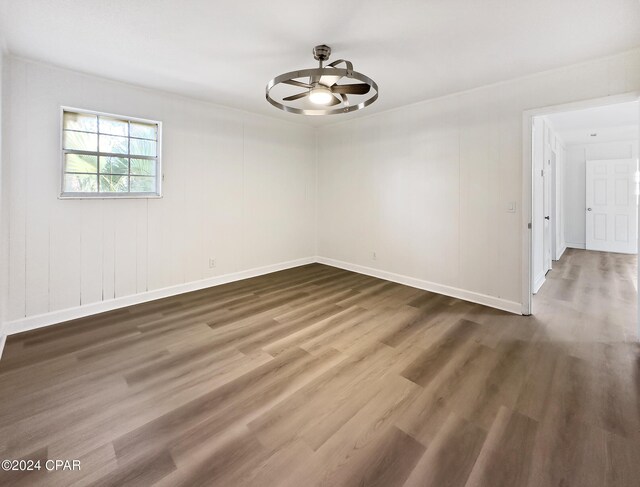 empty room with dark hardwood / wood-style floors and ceiling fan