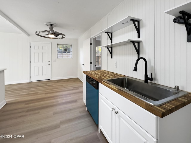 kitchen with hardwood / wood-style floors, wood counters, dishwasher, sink, and white cabinetry