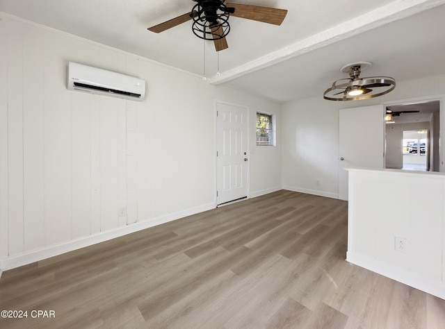 unfurnished living room featuring light hardwood / wood-style floors, an AC wall unit, and ceiling fan