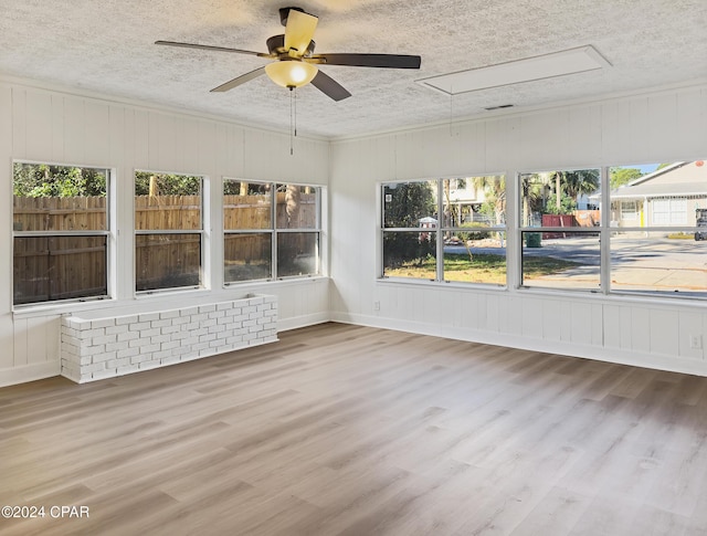 unfurnished sunroom with ceiling fan