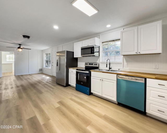 kitchen featuring stainless steel appliances, white cabinetry, and sink