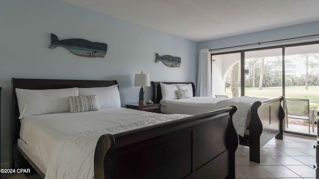 bedroom with light tile patterned floors, access to exterior, and a textured ceiling