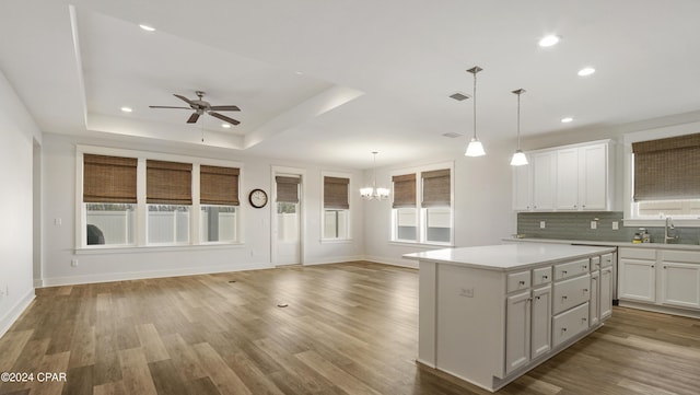 kitchen featuring light hardwood / wood-style floors, a center island, white cabinetry, and hanging light fixtures