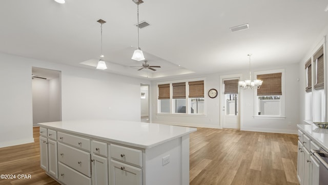 kitchen with a center island, ceiling fan with notable chandelier, light hardwood / wood-style floors, and a wealth of natural light