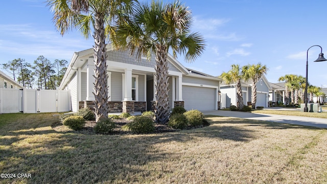 view of front facade featuring a porch, a front yard, and a garage