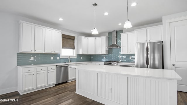 kitchen with wall chimney exhaust hood, stainless steel appliances, dark wood-type flooring, white cabinetry, and a kitchen island