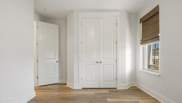 unfurnished bedroom featuring light hardwood / wood-style flooring and a closet