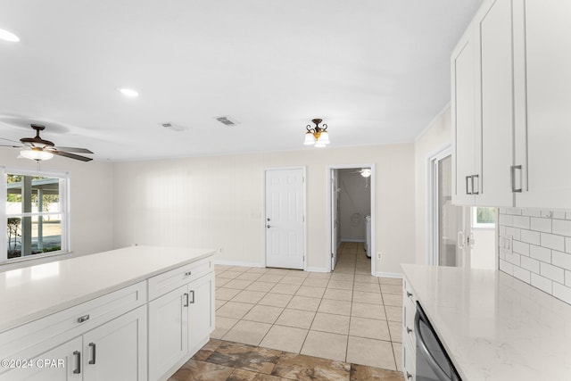 kitchen with tasteful backsplash, ceiling fan, stainless steel dishwasher, and white cabinets