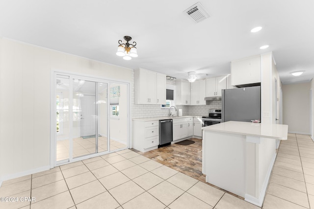 kitchen with light tile patterned flooring, white cabinetry, tasteful backsplash, appliances with stainless steel finishes, and a kitchen breakfast bar