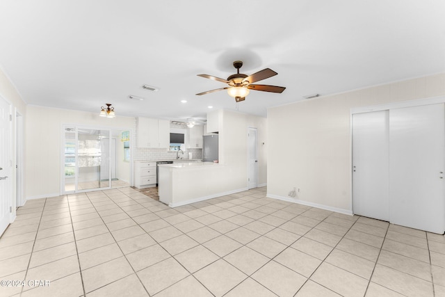 kitchen featuring white cabinetry, stainless steel fridge, backsplash, ceiling fan, and kitchen peninsula