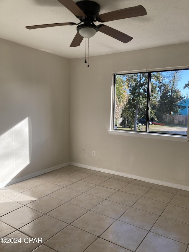 spare room featuring ceiling fan and light tile patterned flooring