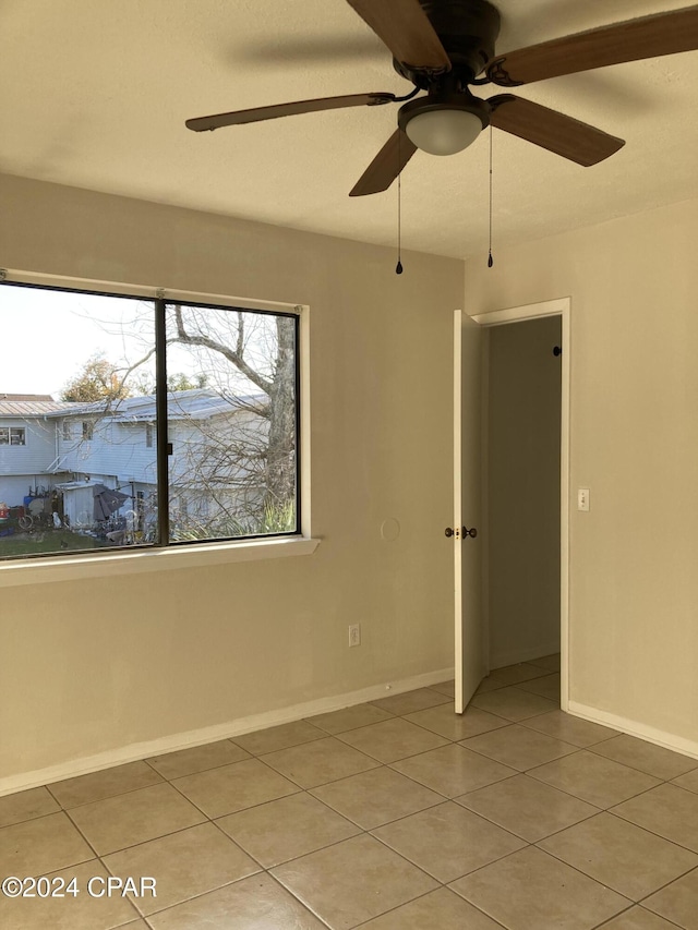 tiled empty room with ceiling fan