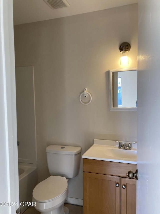 bathroom with a bathtub, vanity, and toilet