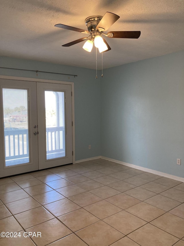 tiled empty room featuring french doors, a textured ceiling, and ceiling fan