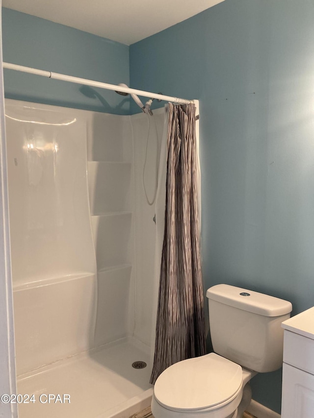 bathroom with vanity, toilet, and walk in shower