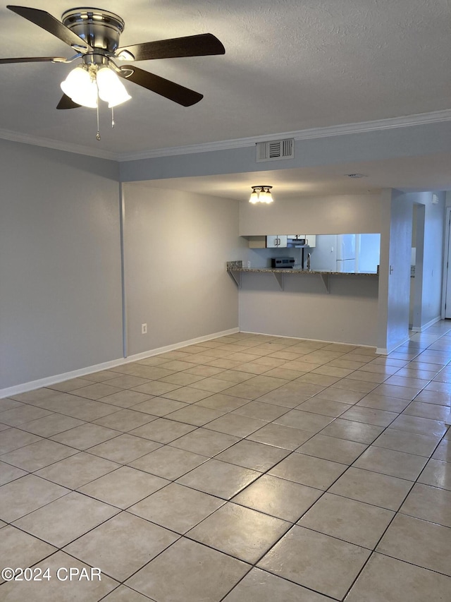 spare room with a textured ceiling, ceiling fan, and crown molding