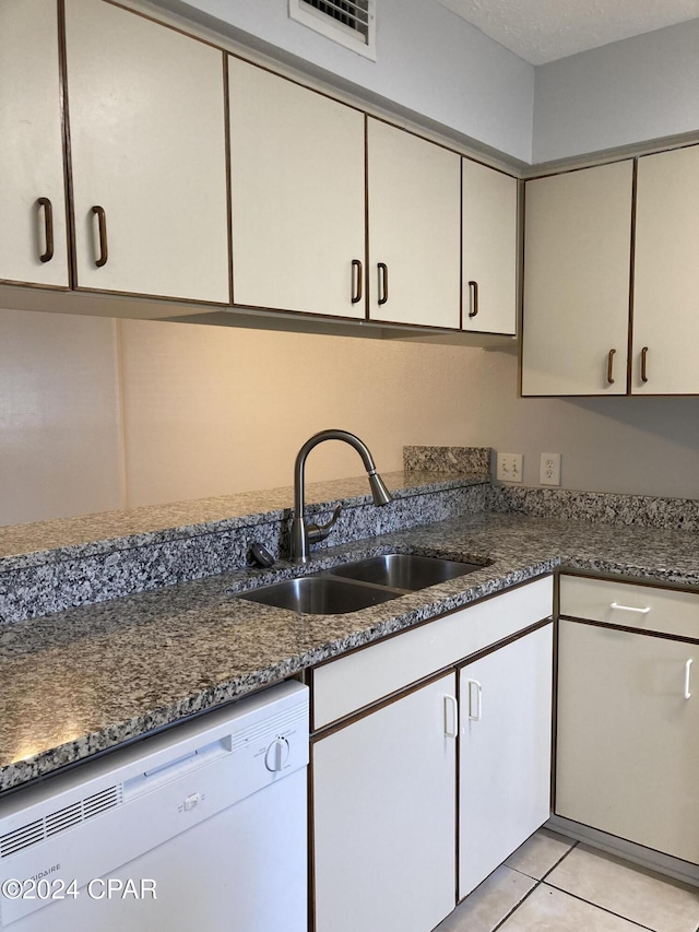 kitchen with sink, light tile patterned flooring, white dishwasher, a textured ceiling, and white cabinets