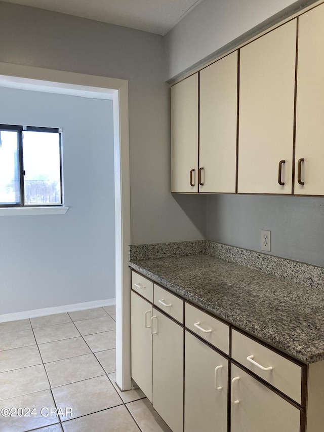 kitchen featuring dark stone countertops and light tile patterned floors