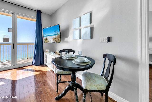 dining area with a water view and light wood-type flooring