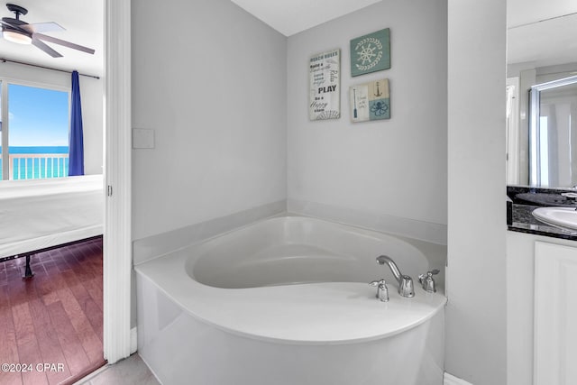 bathroom with wood-type flooring, vanity, a bathtub, and ceiling fan