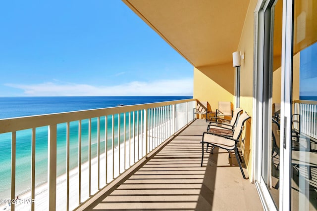 balcony featuring a view of the beach and a water view