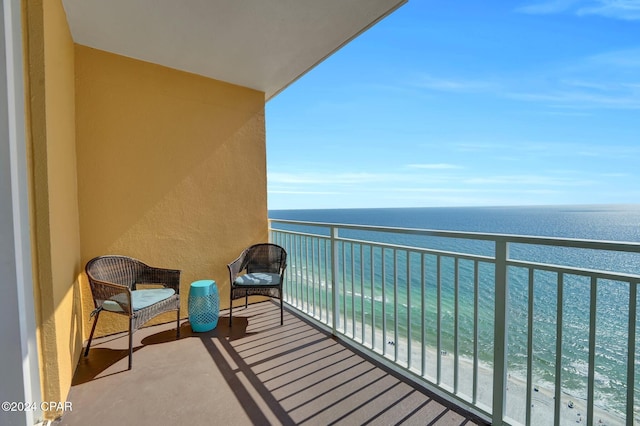 balcony with a water view and a view of the beach