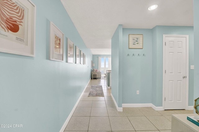 corridor with recessed lighting, light tile patterned flooring, and baseboards