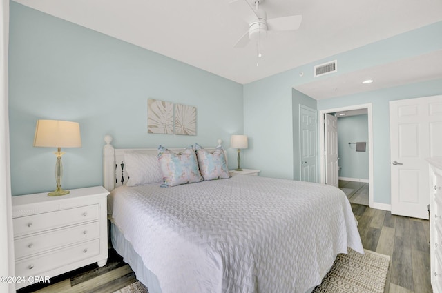 bedroom with ceiling fan, ensuite bathroom, wood finished floors, visible vents, and baseboards