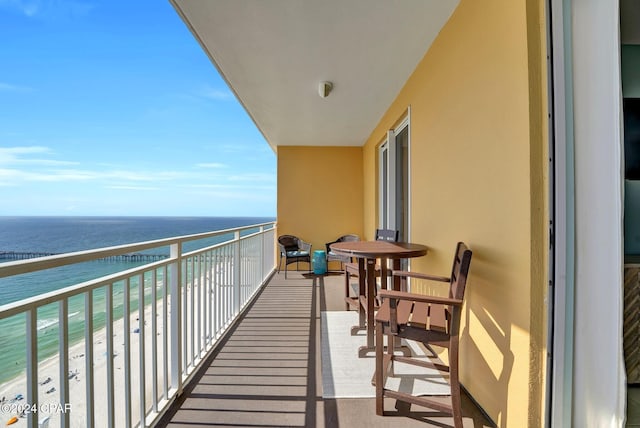 balcony with a water view and a view of the beach