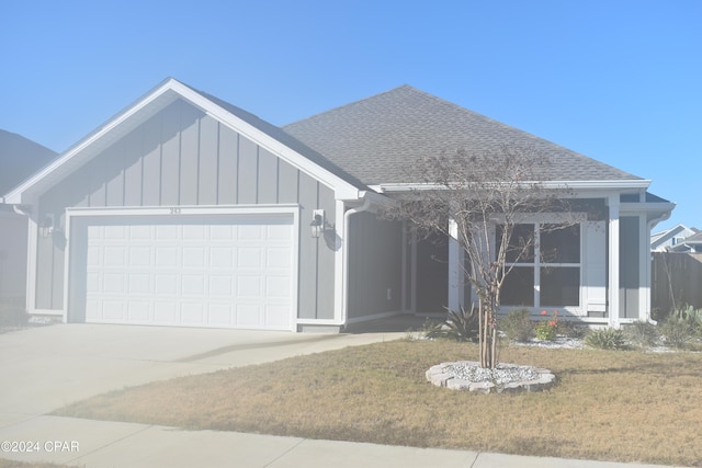 view of front of property with a front yard and a garage