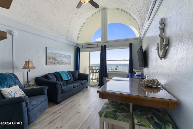 living room with ceiling fan, light hardwood / wood-style flooring, and lofted ceiling