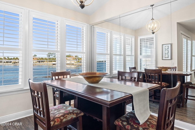 dining space featuring an inviting chandelier, lofted ceiling, dark hardwood / wood-style flooring, and a wealth of natural light