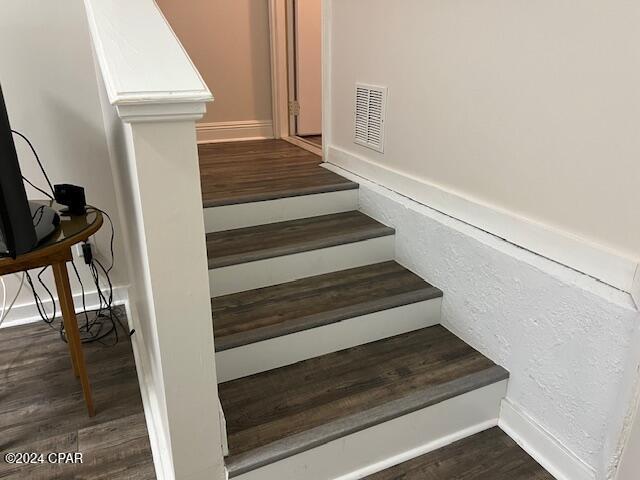 stairs featuring hardwood / wood-style floors