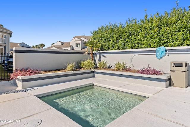 view of pool with a hot tub