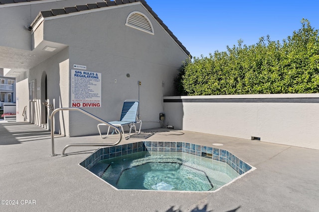 view of pool with a hot tub