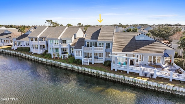 rear view of property featuring a balcony and a water view