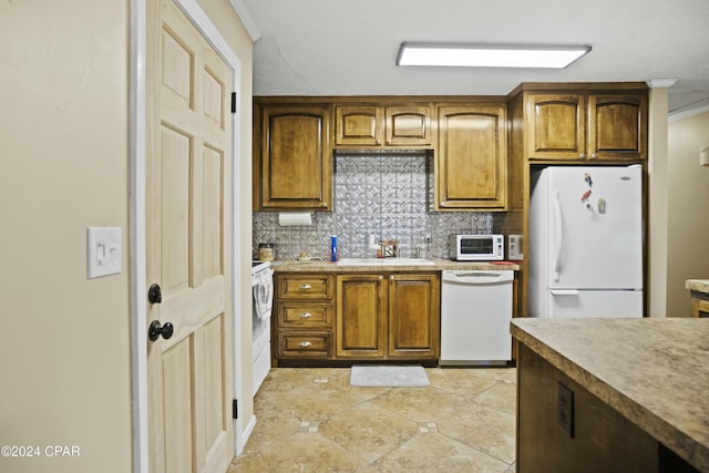 kitchen with sink, backsplash, white appliances, and crown molding