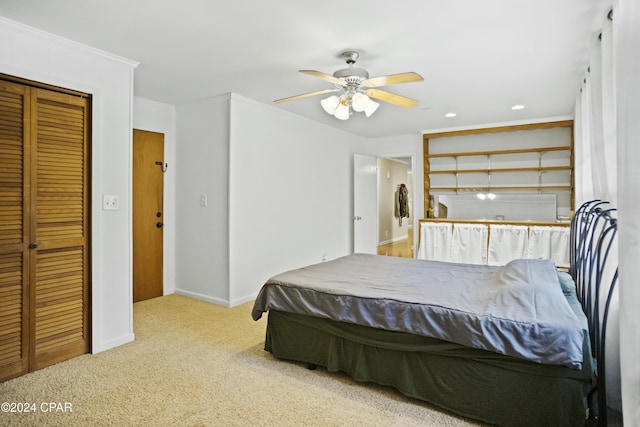 bedroom with light carpet, a closet, ceiling fan, and ornamental molding