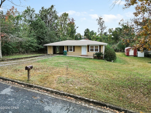 ranch-style house featuring a porch, a storage shed, and a front lawn