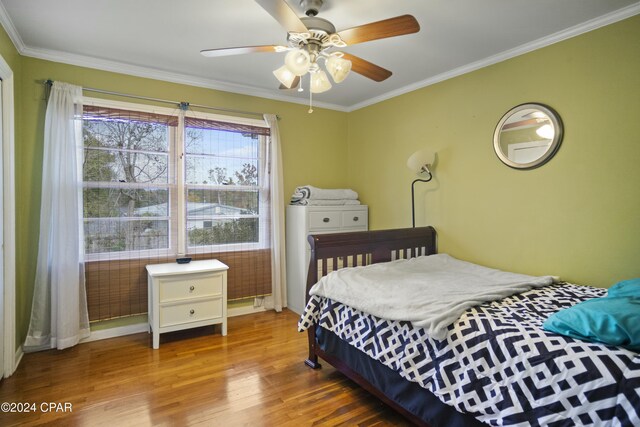 bedroom with ceiling fan, hardwood / wood-style floors, and crown molding