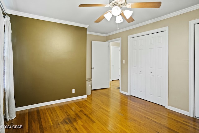 unfurnished bedroom featuring ceiling fan, hardwood / wood-style floors, a closet, and ornamental molding