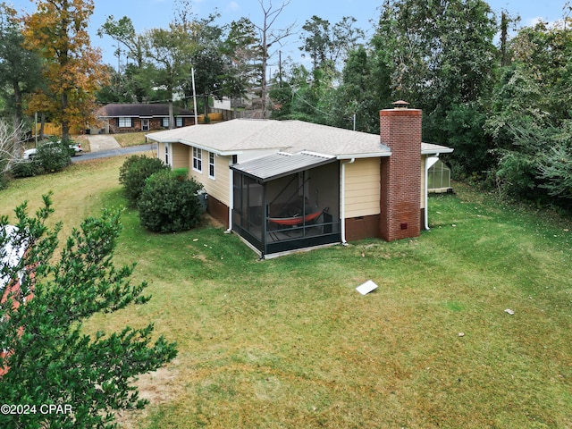 exterior space featuring a sunroom and a yard