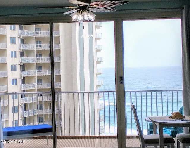 balcony featuring ceiling fan and a water view