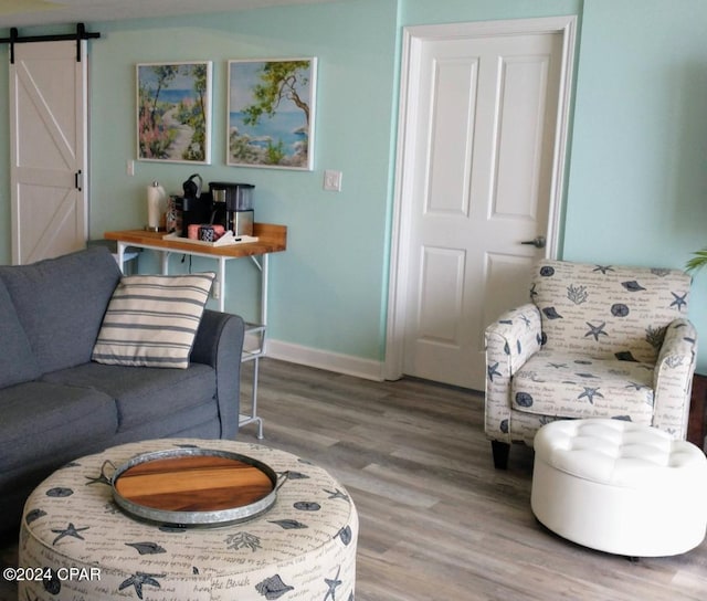 living room with a barn door and wood-type flooring